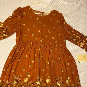 This dress is a spice/gold color with flowers throughout.